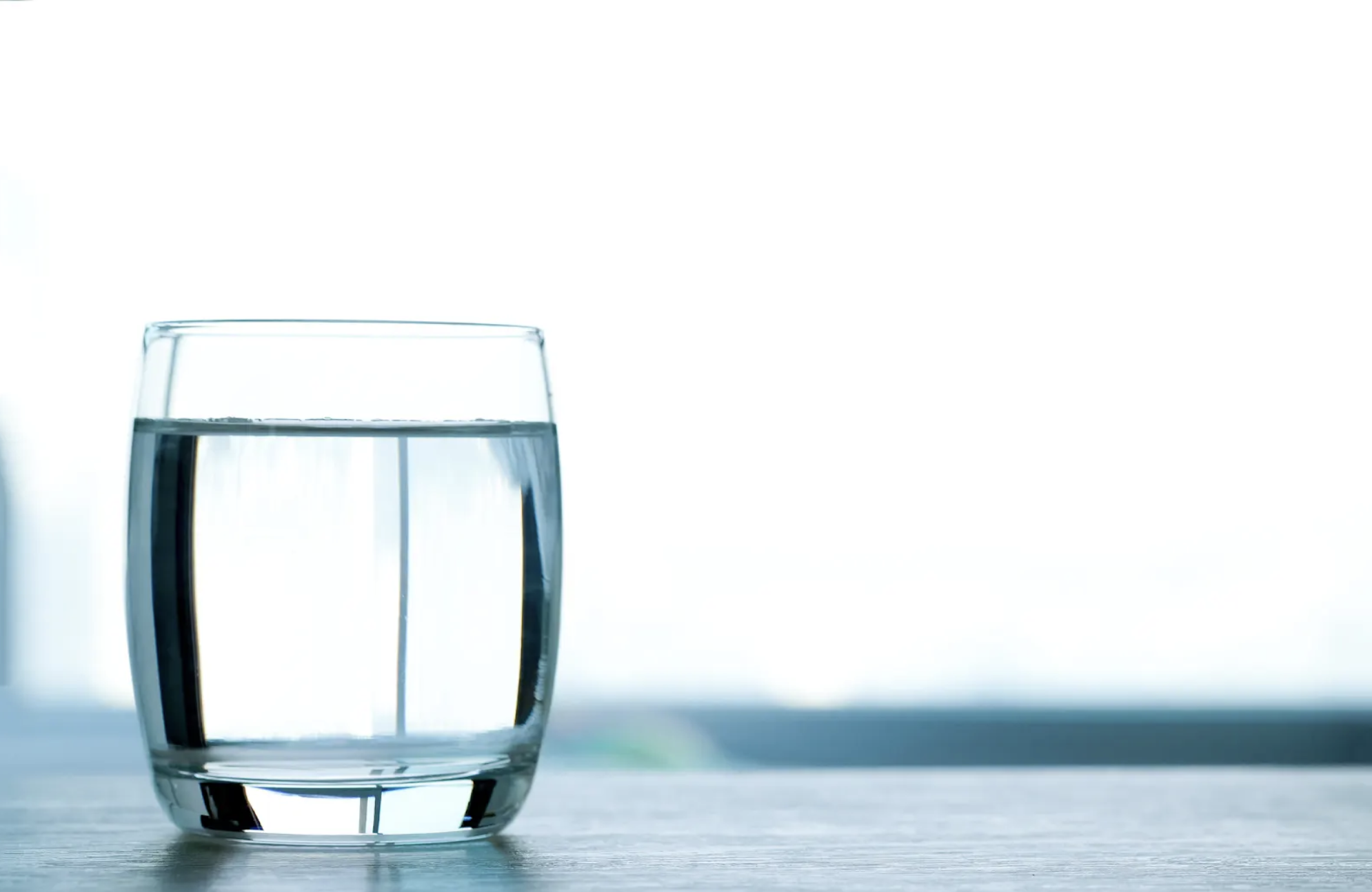 A clear glass of drinking water on a table.